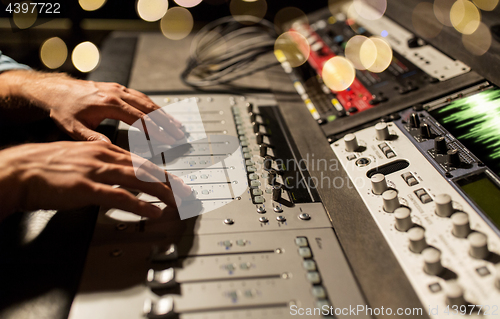 Image of man using mixing console in music recording studio