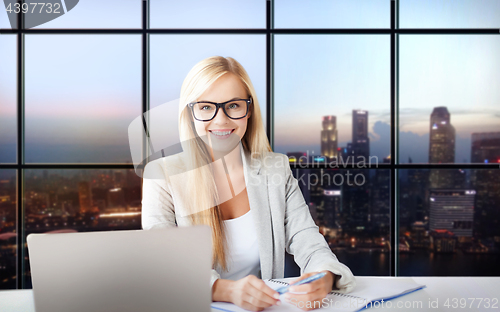 Image of happy businesswoman with documents at office