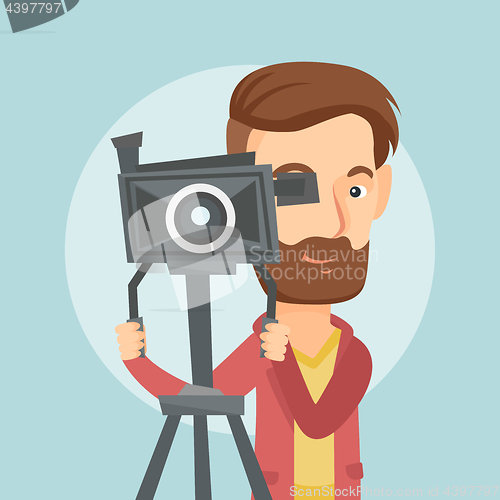 Image of Cameraman with movie camera on tripod.