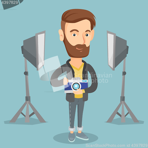 Image of Photographer with camera in photo studio.