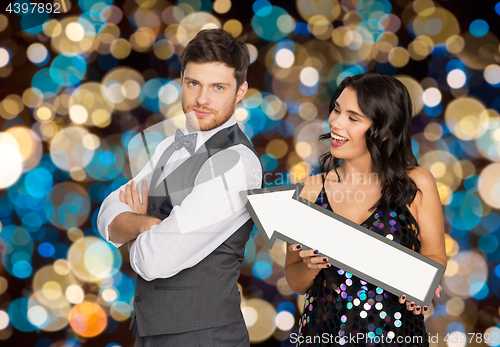 Image of happy couple with big arrow at party