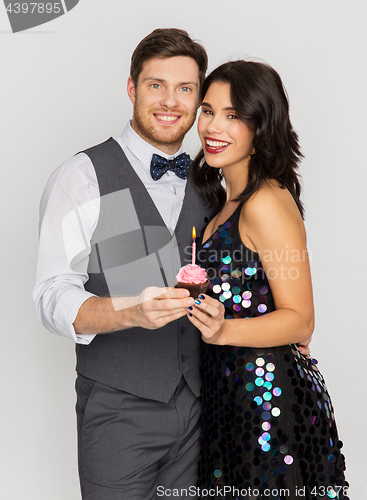 Image of happy couple with cupcake at birthday party