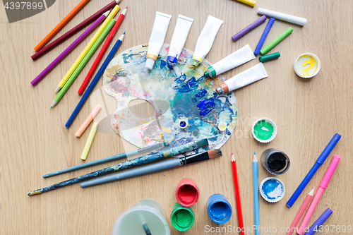 Image of color palette, brushes and paint tubes on table