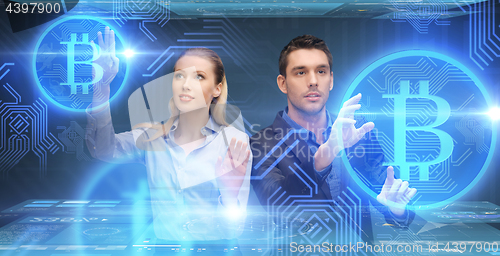 Image of businessman and businesswoman with bitcoins