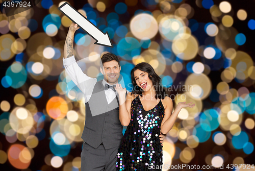 Image of happy couple with big arrow at party