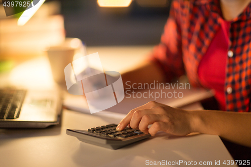 Image of female student hand counting by calculator at home