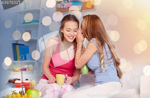 Image of young women drinking tea and gossiping at home