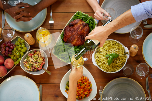 Image of group of people eating and drinking wine