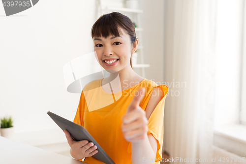 Image of student with tablet pc showing thumbs up at home