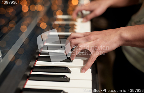 Image of close up of hands playing piano