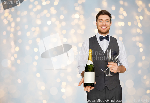 Image of man with bottle of champagne and glasses at party