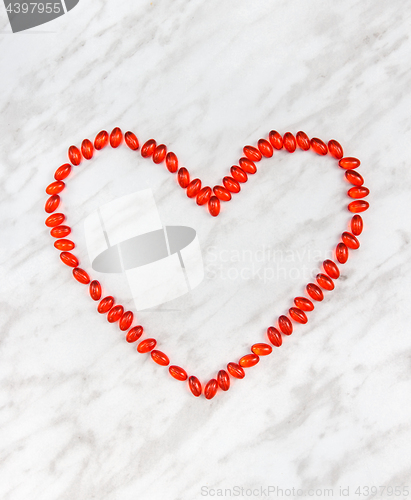 Image of Red pills heart on marble background