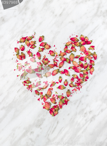 Image of Dried rose flowers heart on marble background