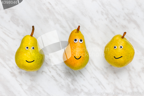 Image of Funny smiling pears on marble background