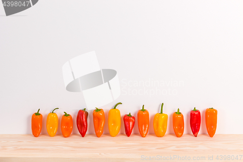 Image of Colorful sweet peppers on wooden surface