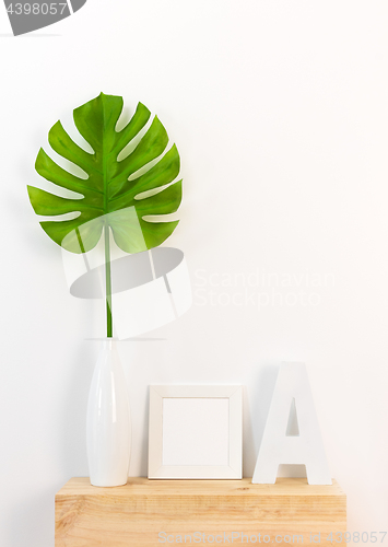 Image of Elegant home decor with picture frame and tropical leaf