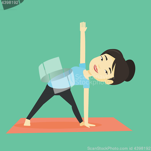 Image of Woman practicing yoga triangle pose.