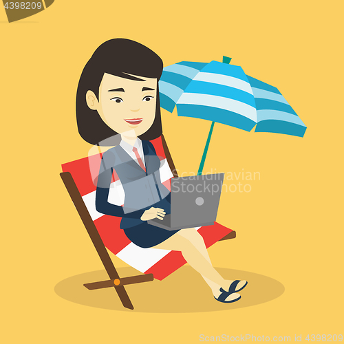 Image of Business woman working on laptop at the beach.