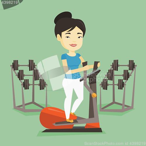 Image of Woman exercising on elliptical trainer.