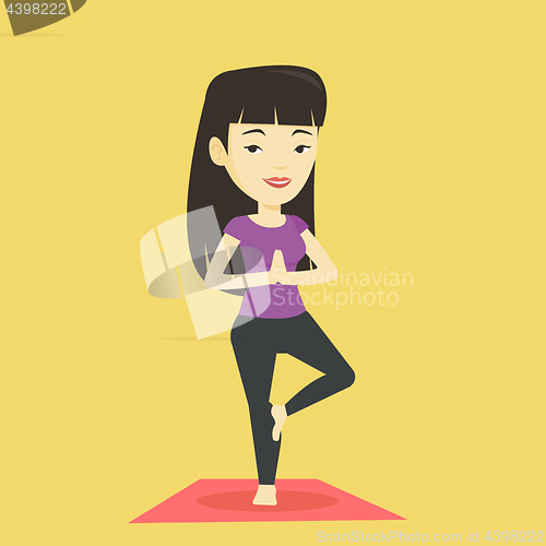 Image of Young woman practicing yoga tree pose.