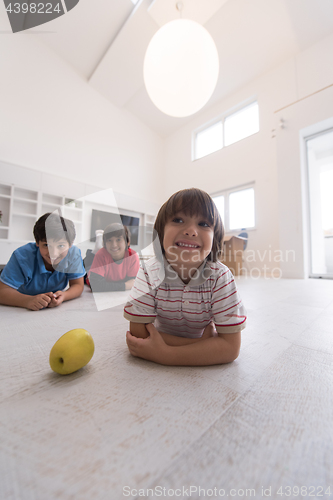 Image of boys having fun with an apple on the floor