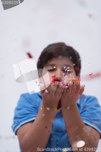 Image of kid blowing confetti