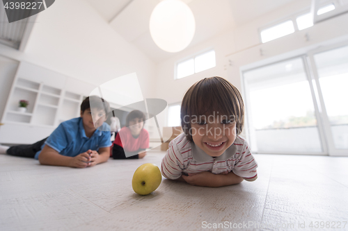 Image of boys having fun with an apple on the floor