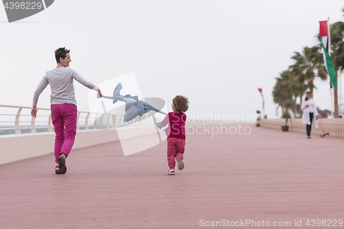 Image of mother and cute little girl on the promenade by the sea