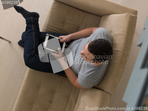 Image of man on sofa using tablet computer