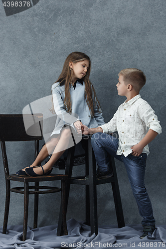 Image of A portrait of little girl and a boy on the gray background