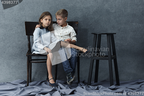 Image of A portrait of little girl and a boy on the gray background