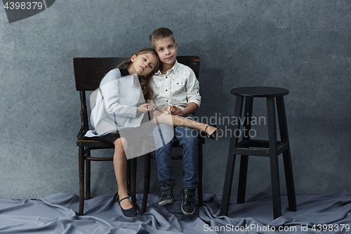 Image of A portrait of little girl and a boy on the gray background