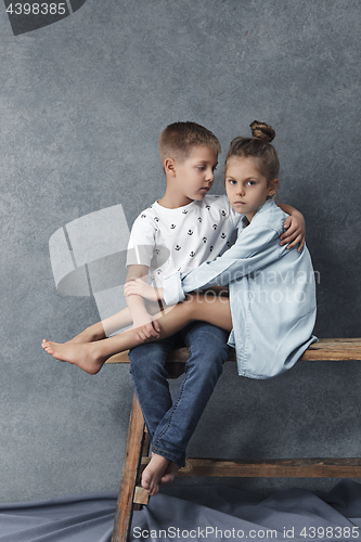 Image of A portrait of little girl and a boy on the gray background