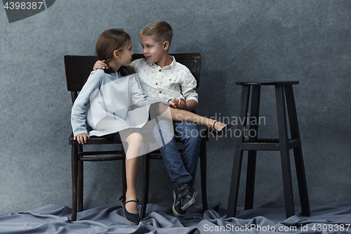 Image of A portrait of little girl and a boy on the gray background