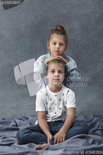 Image of A portrait of little girl and a boy on the gray background