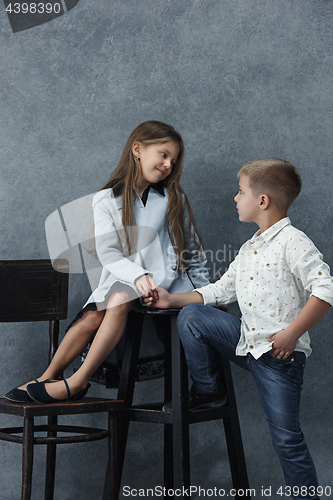 Image of A portrait of little girl and a boy on the gray background