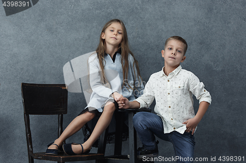 Image of A portrait of little girl and a boy on the gray background