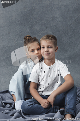 Image of A portrait of little girl and a boy on the gray background