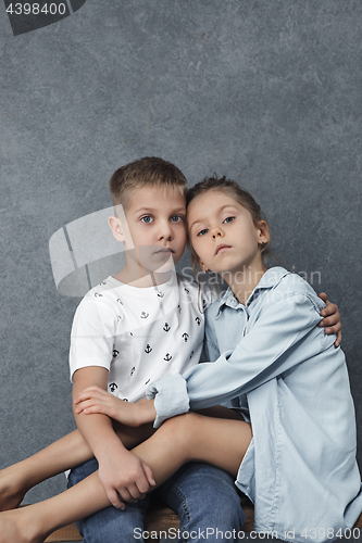 Image of A portrait of little girl and a boy on the gray background