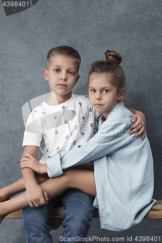 Image of A portrait of little girl and a boy on the gray background