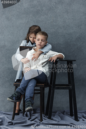 Image of A portrait of little girl and a boy on the gray background