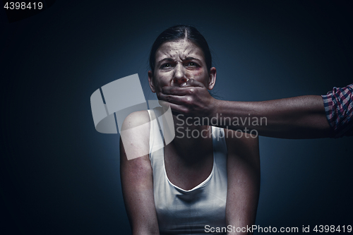 Image of Man covering young woman\'s mouth