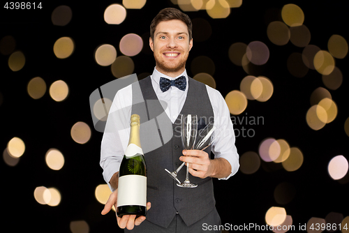 Image of man with bottle of champagne and glasses at party