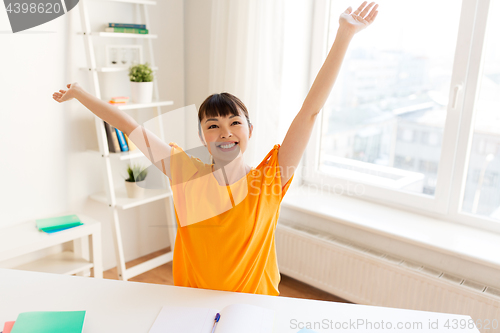 Image of asian student girl celebrating success at home