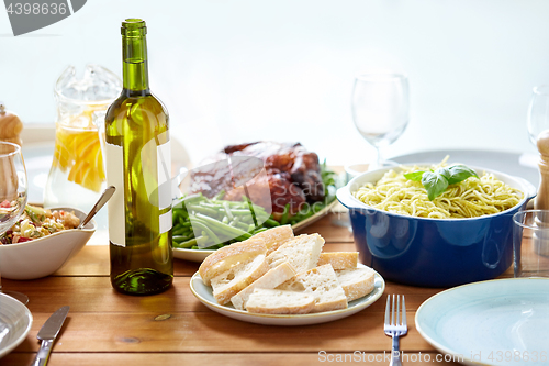 Image of bottle of wine and food on served wooden table