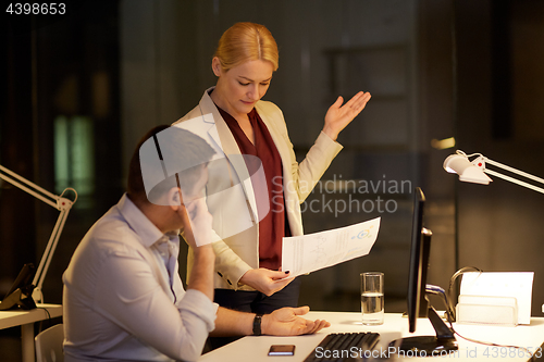 Image of business team with papers working late at office