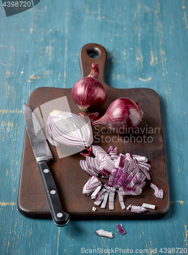 Image of red onion on wooden cutting board