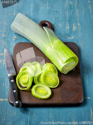 Image of fresh green leek on wooden cutting board