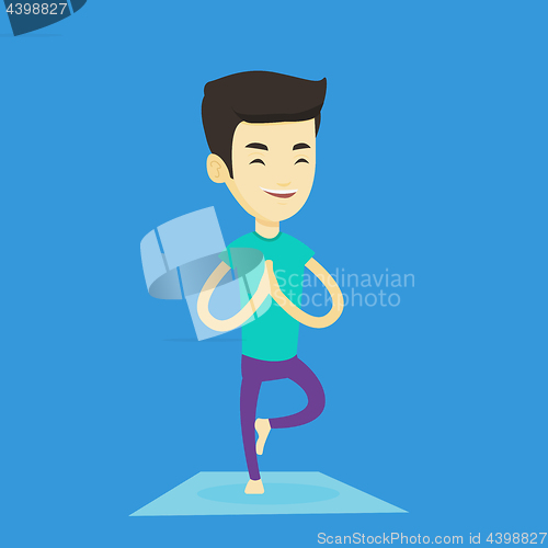 Image of Young man practicing yoga tree pose.