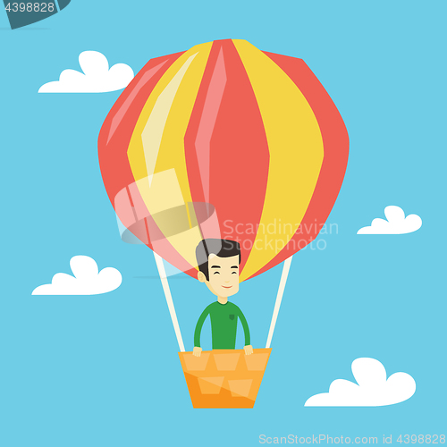 Image of Young man flying in hot air balloon.